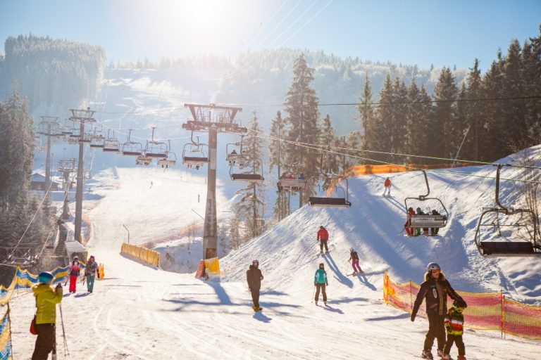skiers-ski-lift-riding-up-ski-resort
